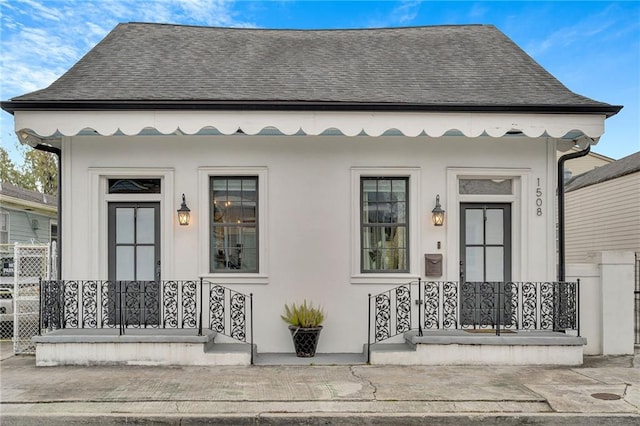 1508 N Roman St, New Orleans, LA 70116 - property entrance with roof with shingles, stucco siding, fence, and covered porch