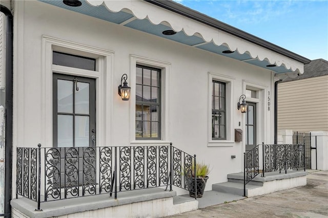1508 N Roman St, New Orleans, LA 70116 - doorway to property featuring covered porch and stucco siding