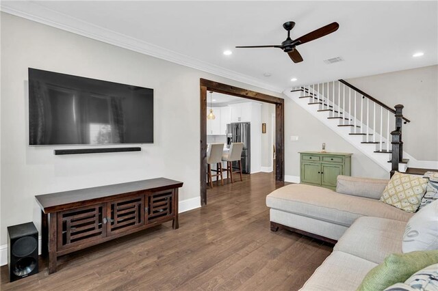 living room featuring hardwood / wood-style floors, ornamental molding, and ceiling fan