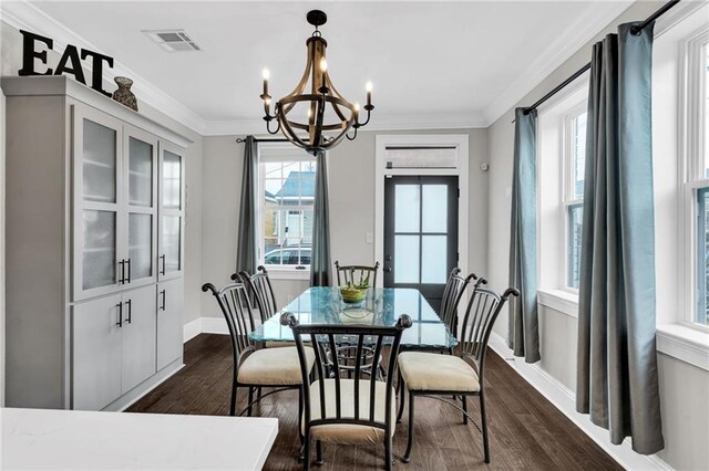 dining room featuring ornamental molding, an inviting chandelier, and dark hardwood / wood-style flooring