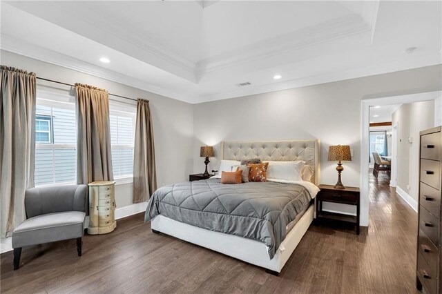 bedroom featuring dark hardwood / wood-style floors, ornamental molding, and a raised ceiling