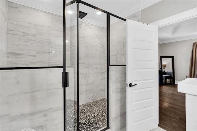 bathroom with crown molding, wood-type flooring, and walk in shower