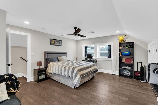 bedroom with dark hardwood / wood-style flooring, vaulted ceiling, and ceiling fan