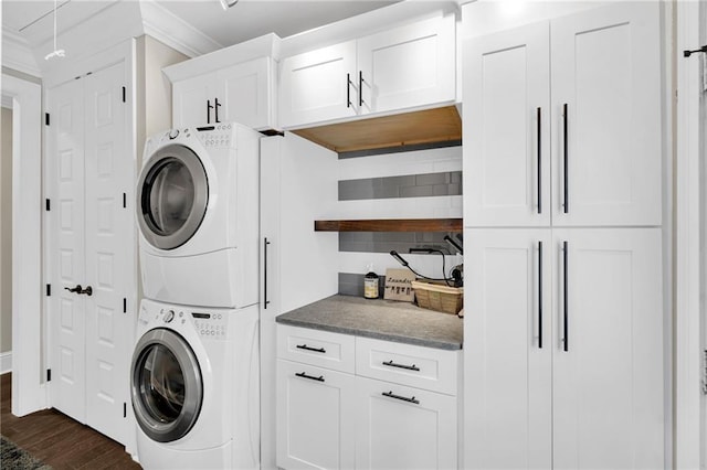 1508 N Roman St, New Orleans, LA 70116 - laundry room featuring cabinet space, ornamental molding, stacked washer / drying machine, and dark wood finished floors