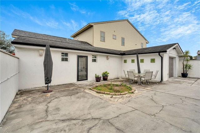 rear view of house with a garage and a patio