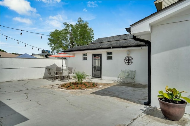 1508 N Roman St, New Orleans, LA 70116 - exterior space featuring roof with shingles, stucco siding, a patio area, outdoor dining area, and fence