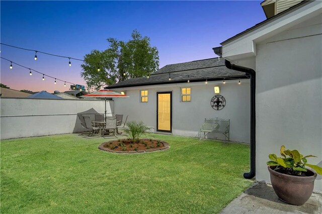 1508 N Roman St, New Orleans, LA 70116 - rear view of house featuring a patio, stucco siding, a yard, fence, and a shingled roof