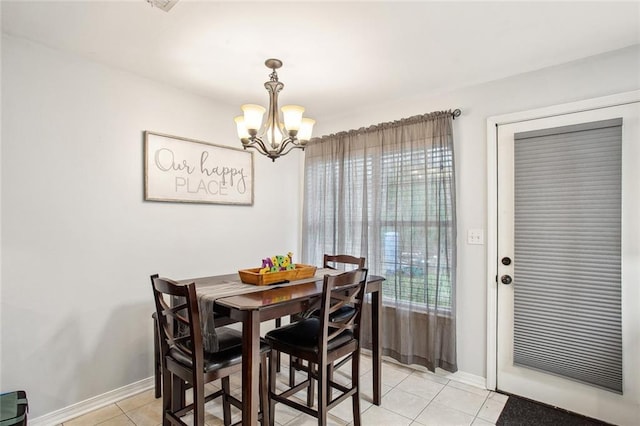 dining area featuring light tile patterned floors and an inviting chandelier