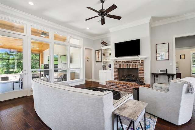 living room with dark hardwood / wood-style flooring, ceiling fan, a fireplace, and ornamental molding