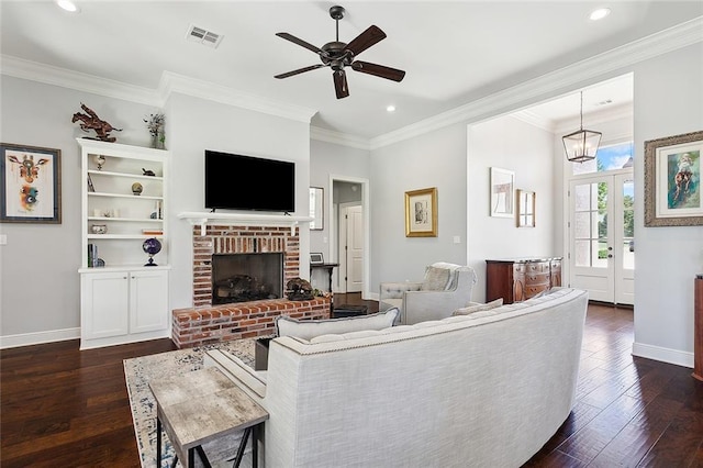 living room featuring a fireplace, dark wood-type flooring, ceiling fan with notable chandelier, and ornamental molding