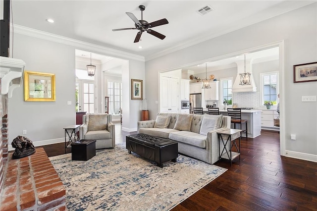 living room with dark hardwood / wood-style floors, a brick fireplace, ceiling fan, and crown molding