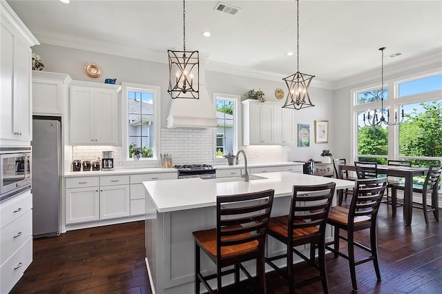 kitchen featuring pendant lighting, a center island with sink, stainless steel appliances, and sink