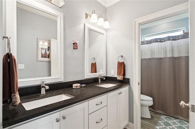 bathroom with a shower with curtain, crown molding, wood-type flooring, toilet, and vanity