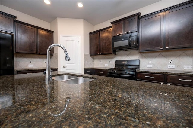 kitchen featuring black appliances, dark brown cabinets, sink, and dark stone counters