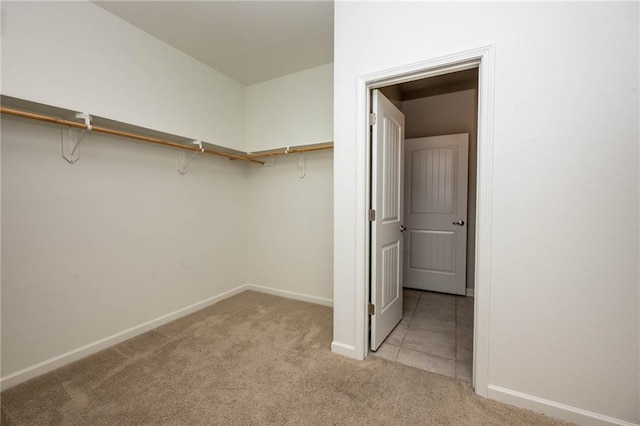 walk in closet with light carpet