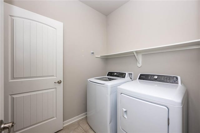 laundry area featuring washing machine and dryer and light tile patterned floors