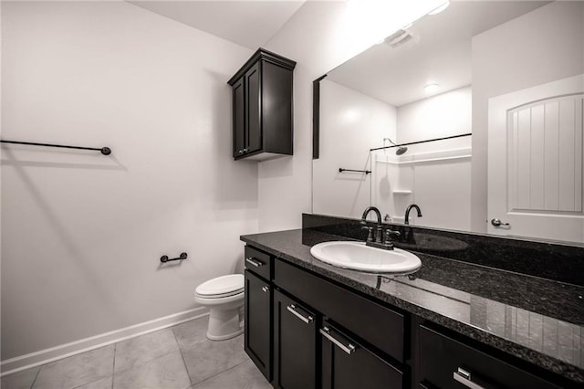 bathroom featuring tile patterned flooring, toilet, vanity, and walk in shower