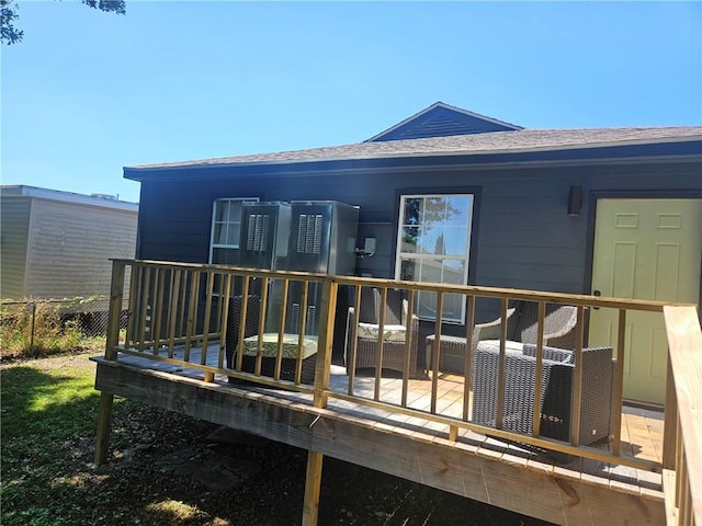 rear view of property with a wooden deck and an outdoor hangout area