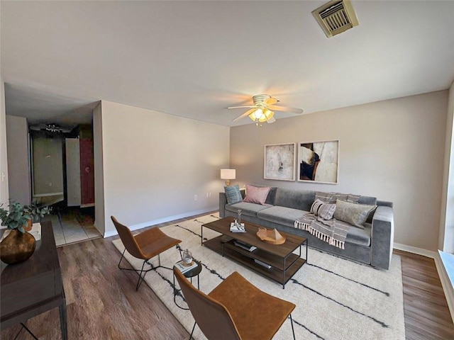 living room with ceiling fan and dark hardwood / wood-style flooring