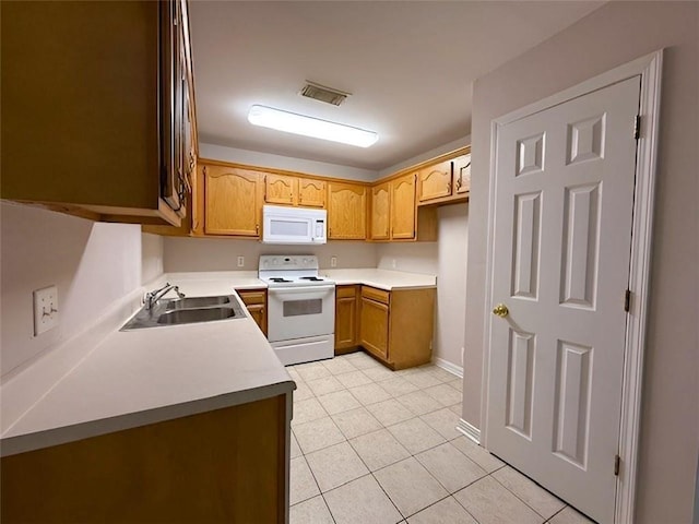 kitchen with light tile patterned floors, white appliances, and sink