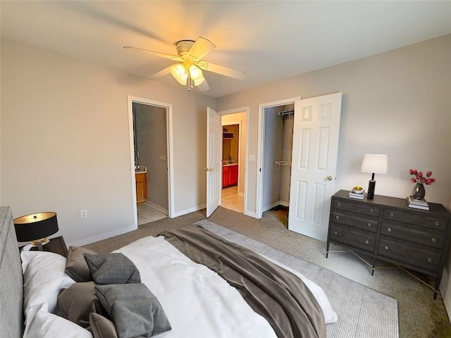 carpeted bedroom featuring ceiling fan and ensuite bath