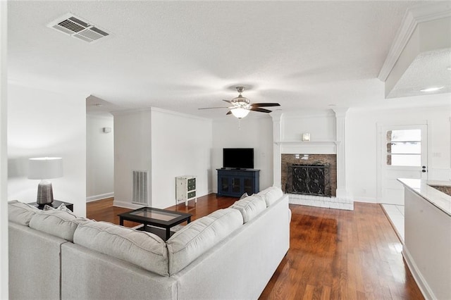 living room with ornamental molding, ceiling fan, and dark wood-type flooring