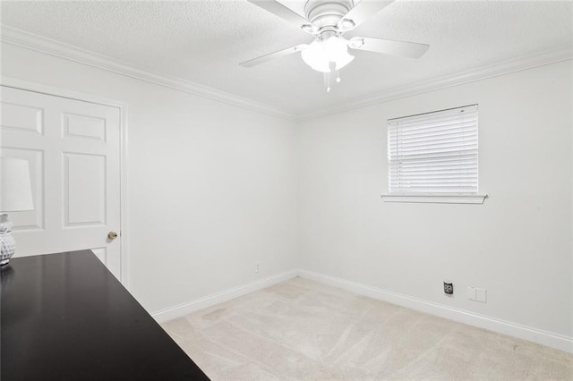 carpeted spare room featuring ceiling fan, ornamental molding, and a textured ceiling