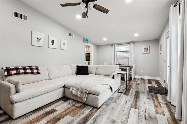 living room featuring ceiling fan, wood-type flooring, and lofted ceiling