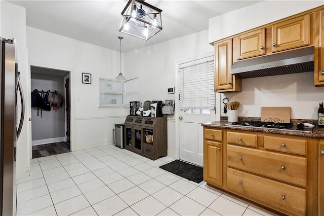 kitchen with pendant lighting, appliances with stainless steel finishes, a notable chandelier, and light tile patterned flooring