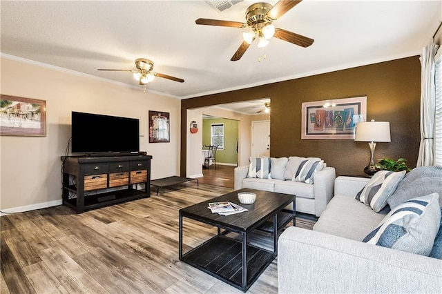 living room featuring wood-type flooring and crown molding