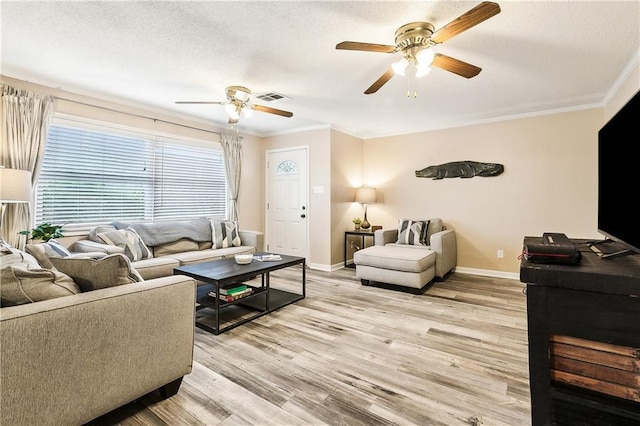 living room with crown molding, ceiling fan, a textured ceiling, and light wood-type flooring