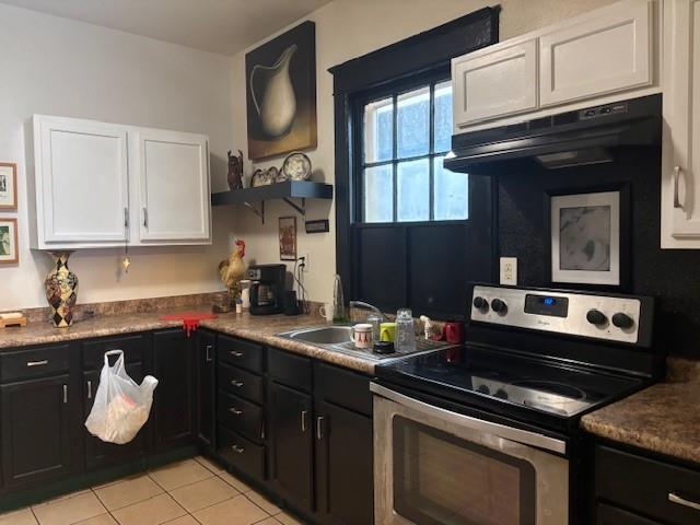 kitchen featuring white cabinetry, sink, light tile patterned floors, and stainless steel electric range