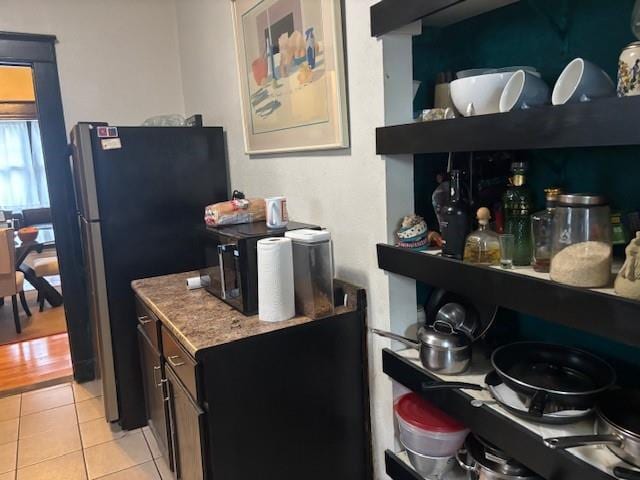 kitchen with light tile patterned floors and fridge