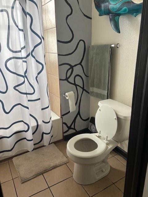 bathroom with tile patterned flooring, toilet, and shower / tub combo