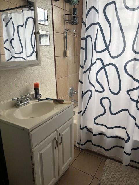 bathroom featuring tile patterned floors, vanity, and shower / bath combo