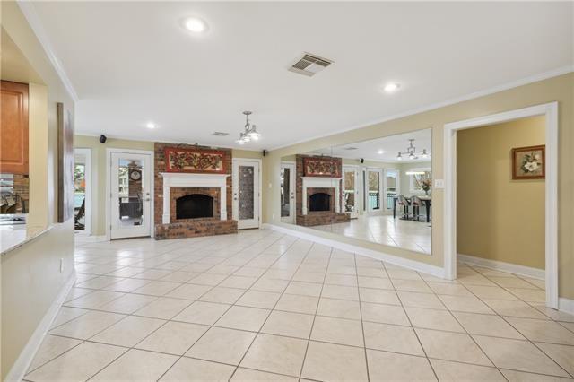 unfurnished living room with light tile patterned floors, a fireplace, and ornamental molding