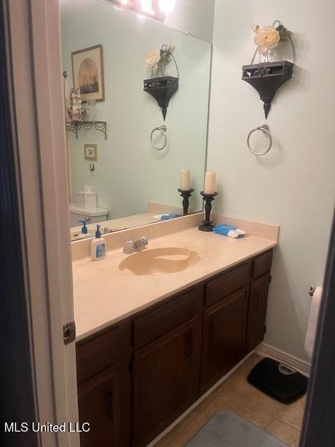 bathroom featuring tile patterned floors, vanity, and toilet