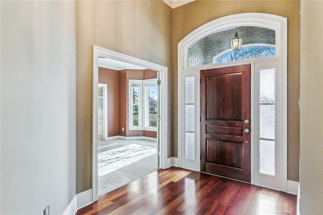 foyer with wood-type flooring and ornamental molding