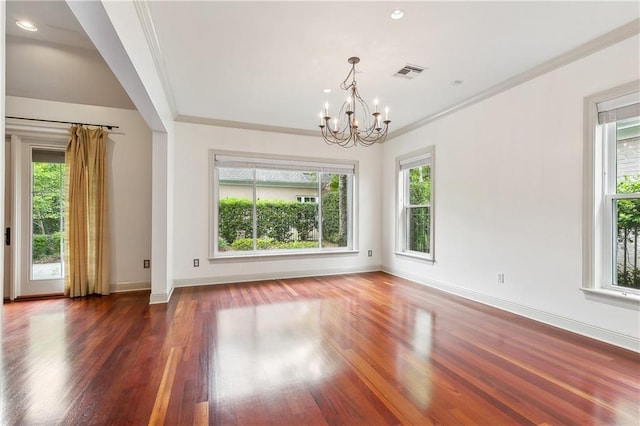 interior space featuring an inviting chandelier, wood finished floors, visible vents, crown molding, and baseboards
