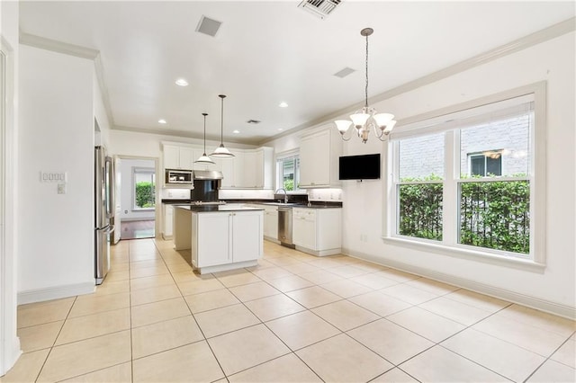 kitchen featuring stainless steel appliances, a sink, dark countertops, visible vents, and ornamental molding