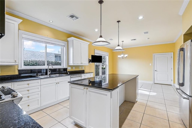 kitchen with a center island, sink, hanging light fixtures, stainless steel fridge, and white cabinets