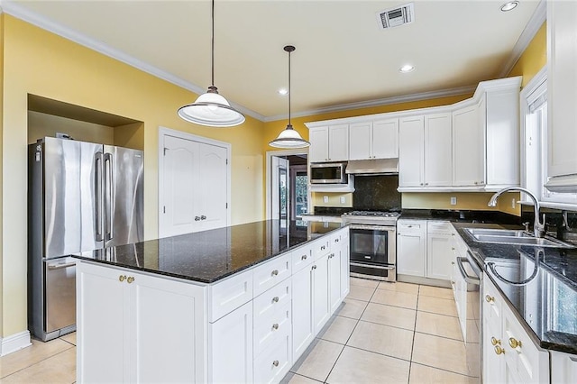 kitchen with white cabinets, a kitchen island, stainless steel appliances, and decorative light fixtures