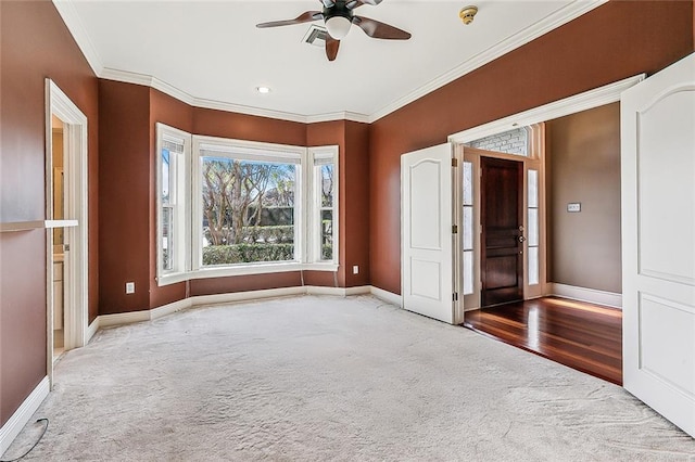 spare room with carpet, ceiling fan, and crown molding