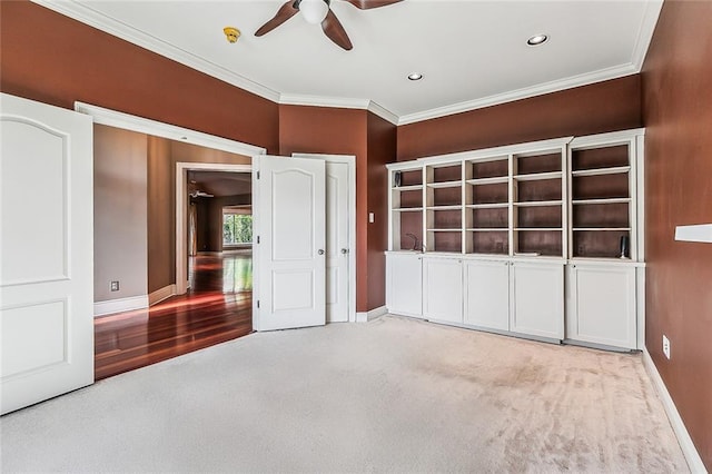 unfurnished bedroom with carpet flooring, ceiling fan, and crown molding