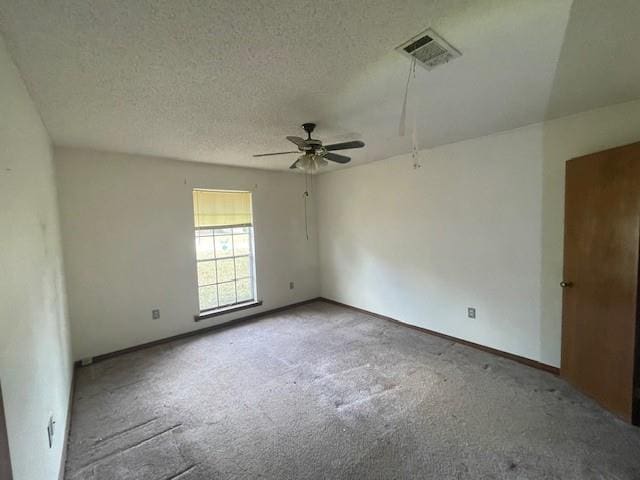 carpeted spare room with ceiling fan and a textured ceiling