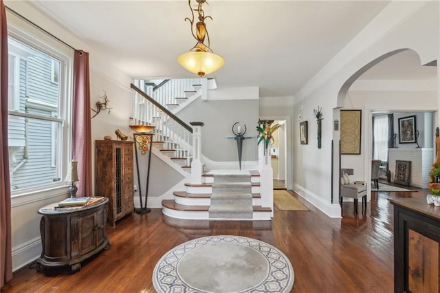 entryway with a fireplace and dark wood-type flooring