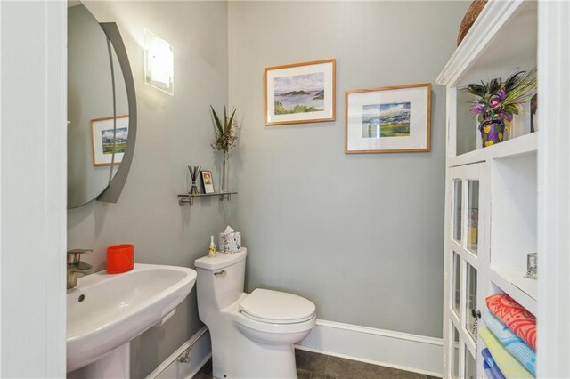 bathroom featuring toilet, tile patterned floors, and sink