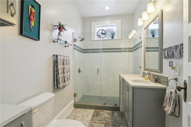 bathroom featuring walk in shower, vanity, tile patterned flooring, and toilet