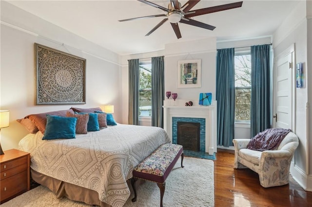 bedroom with ceiling fan, multiple windows, and hardwood / wood-style floors