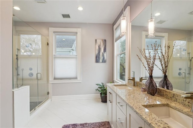 bathroom featuring a shower with door and vanity